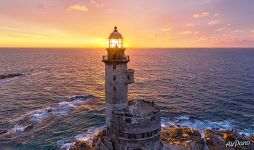 Rising sun rays through the lighthouse